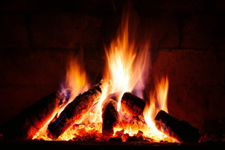 A blazing log fire in a fireplace - your chimney needs to be cleaned yearly for safety.