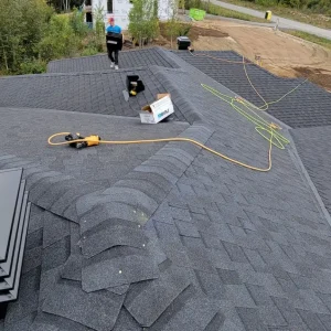 Roofer carries Certainteed materials across asphalt shingle roof Roofer carries Certainteed materials across asphalt shingle roof.